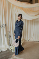 Navy Floral Embroidered Co-Ord Set — lifestyle shot in decorated interior, navy top and wide-leg trouser with pink handbag