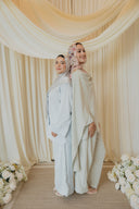 Sage Green Cape Co-Ord Set — back-to-back pose, cape draping visible, styled alongside a matching pastel look