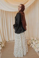 Black Satin Shirt with Wavy Embroidered Hem styled with White Chiffon Skirt with Black Floral Print — full-length back view